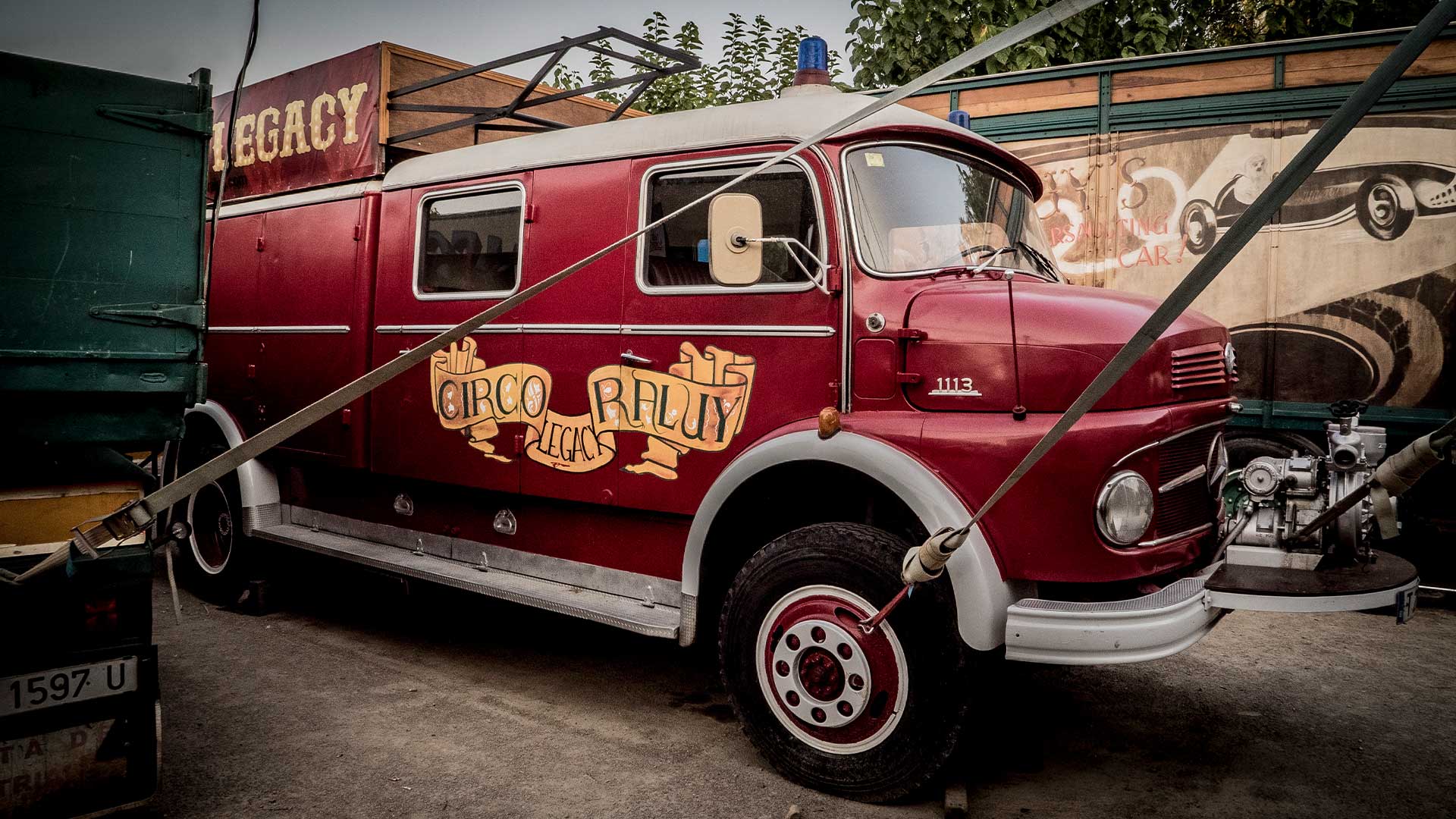 Camión antiguo del Circo Raluy Legacy con sirenas azules sosteniendo la carpa del circo