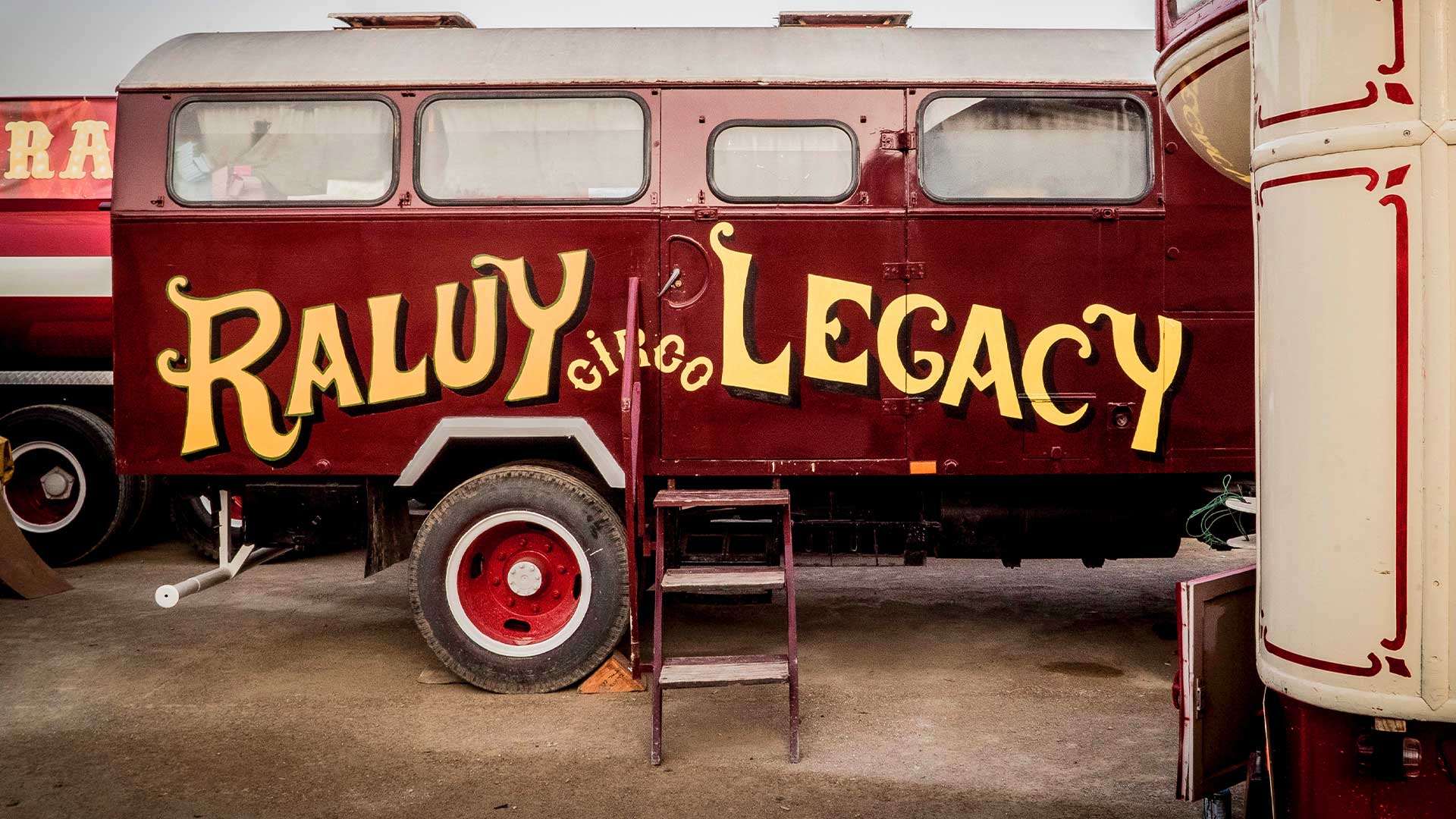 Antiguo camión caravana del circo Raluy Legacy rojo con letras amarillas