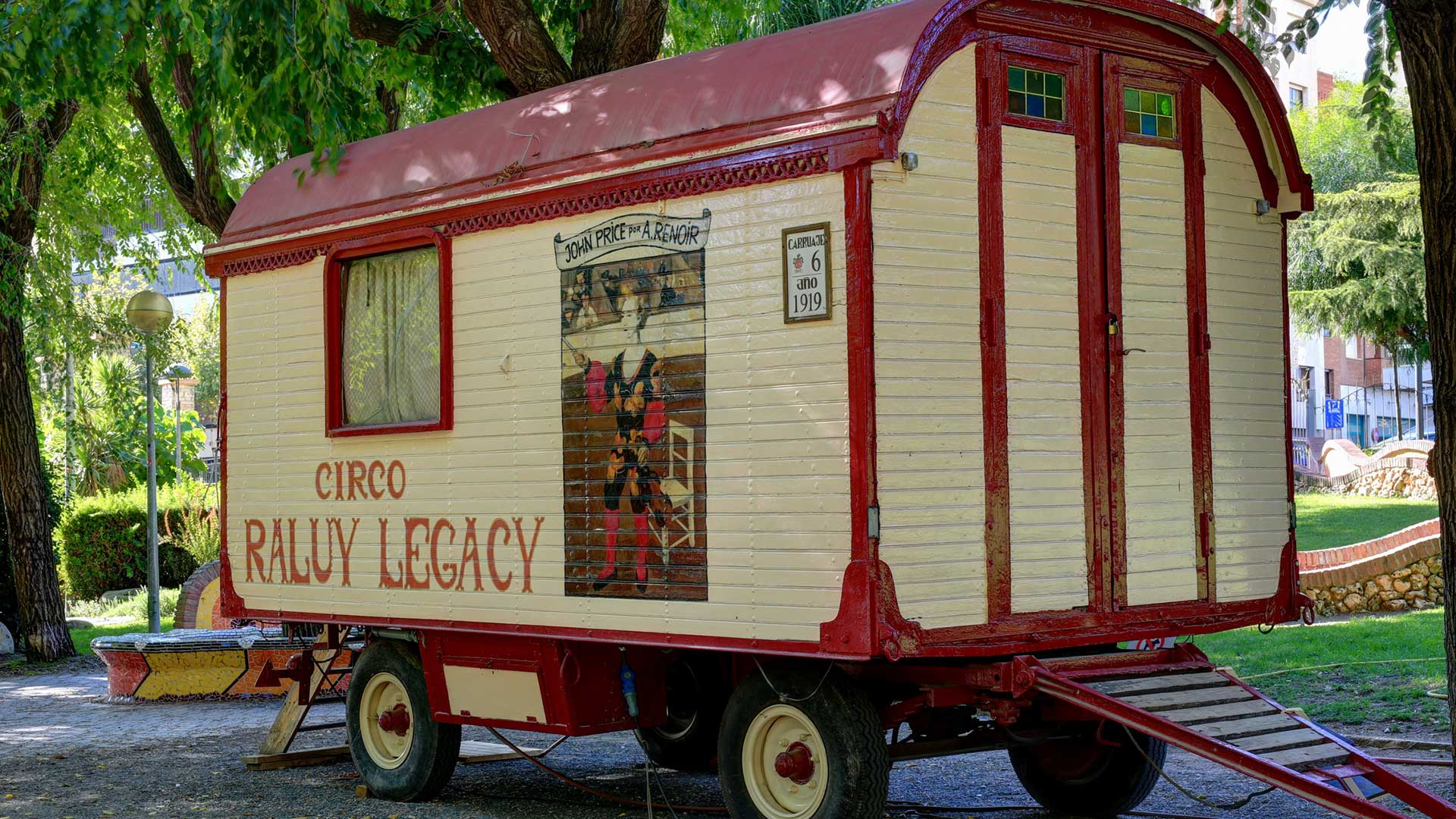 Carruaje de la caravana del Circo Raluy Legacy. Es de color rojo y blanco y está pintado. Tiene apariencia antigua