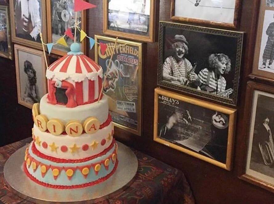 Tarta de cumpleaños de tres pisos decorada con una carpa de circo en una celebración de cumpleaños en el Circo Raluy Legacy. Celebraciones. Experiencias.